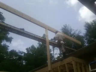 Carpenter setting a ridge beam over a new addition frame — Ice Dam Removal by Roofing Brothers in Sandusky